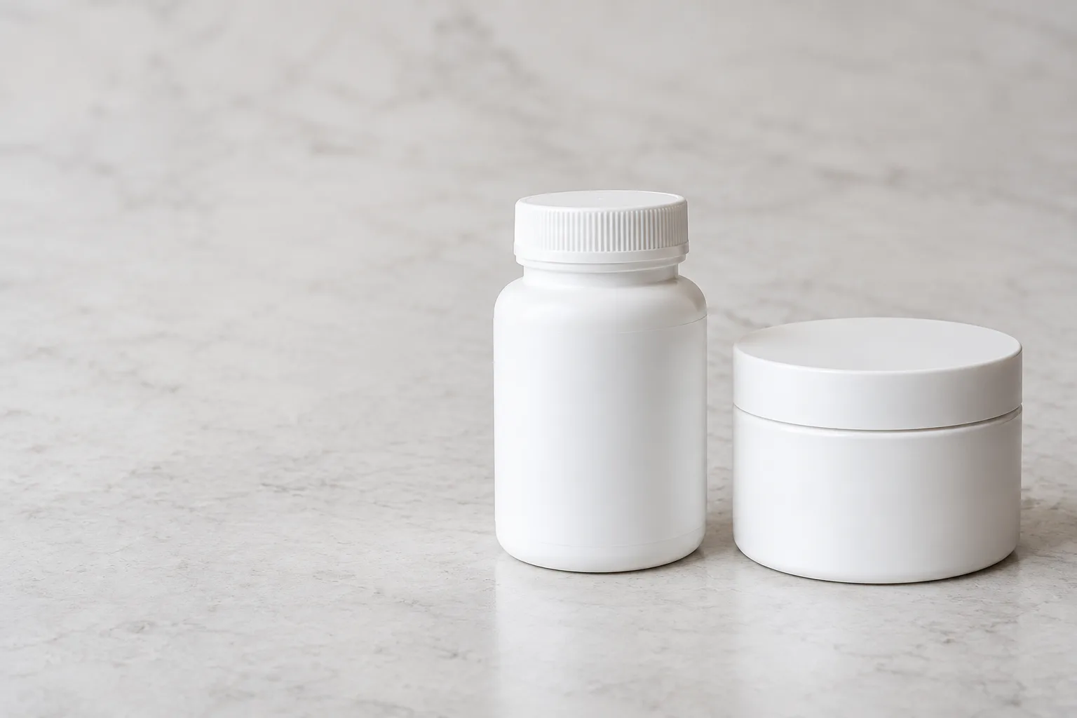 Two plain unbranded medication containers side by side on a pale surface